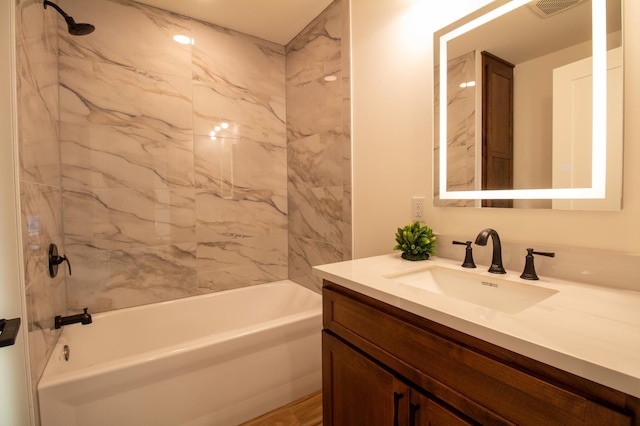 bathroom with tiled shower / bath and vanity