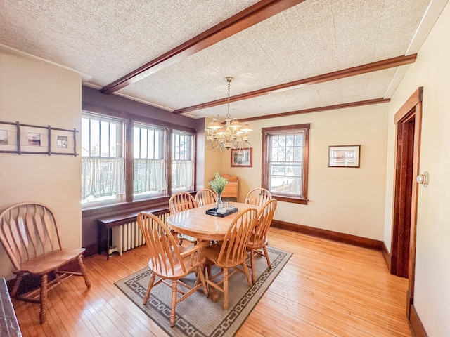 dining space with radiator heating unit, beam ceiling, a notable chandelier, light hardwood / wood-style floors, and a textured ceiling