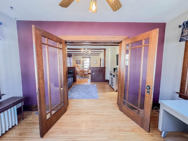 hall with an inviting chandelier and light hardwood / wood-style floors