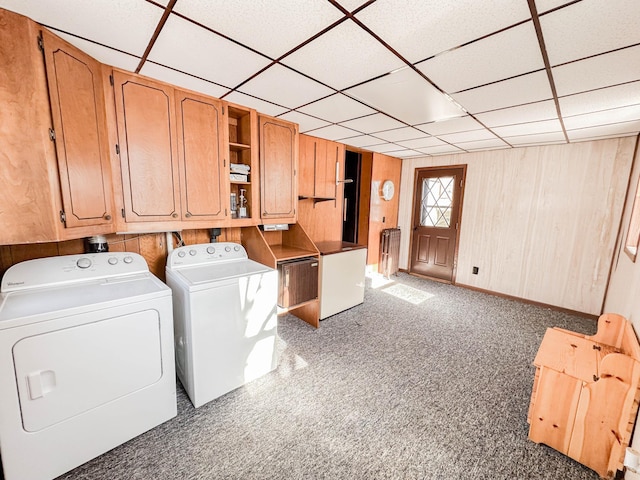 washroom featuring washer and dryer, wooden walls, cabinets, and carpet