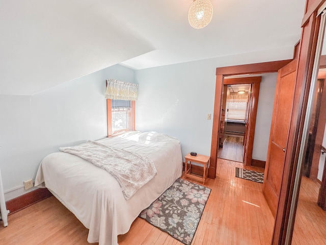 bedroom featuring vaulted ceiling and light hardwood / wood-style floors