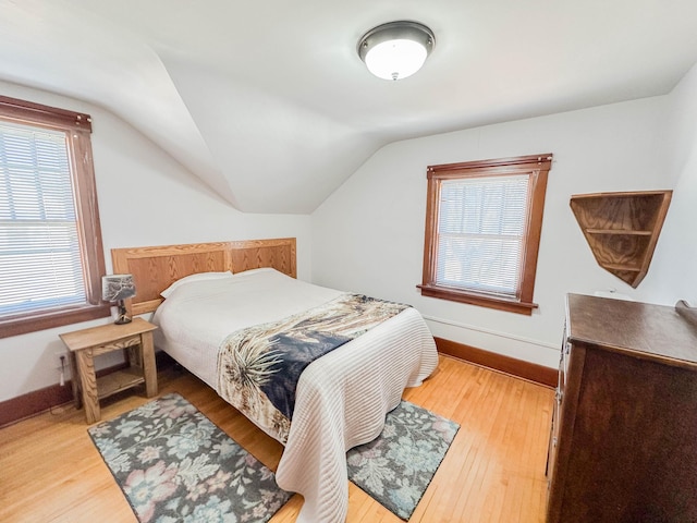 bedroom with lofted ceiling and light hardwood / wood-style floors