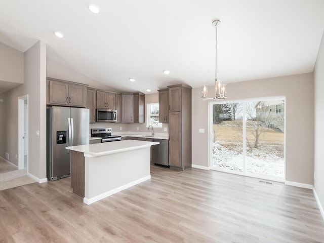 kitchen featuring sink, a center island, a notable chandelier, pendant lighting, and stainless steel appliances