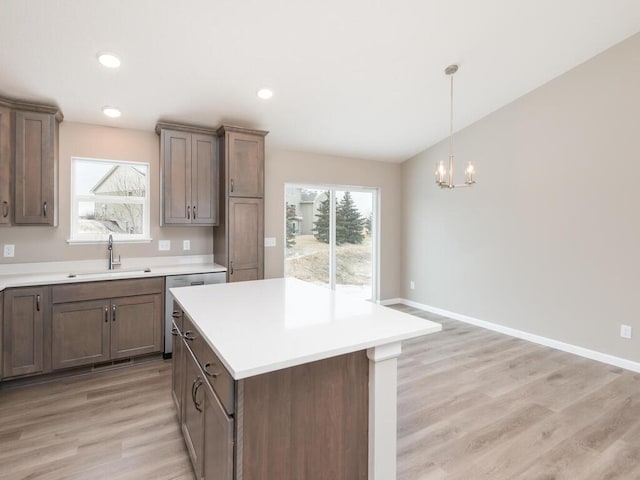 kitchen featuring sink, light hardwood / wood-style flooring, a center island, and a healthy amount of sunlight