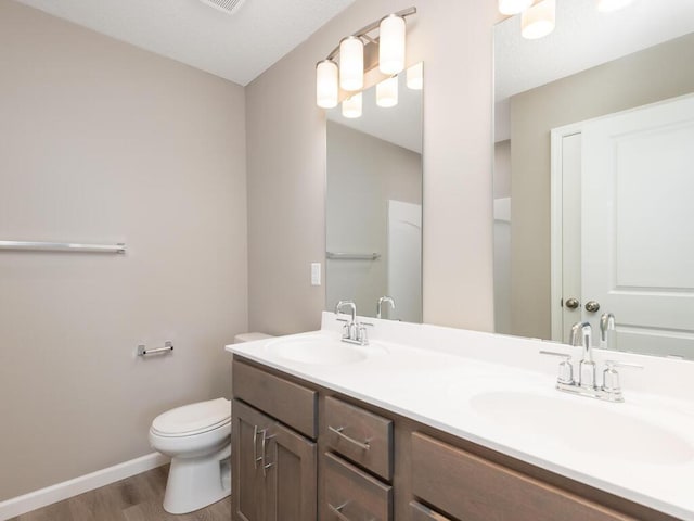 bathroom featuring hardwood / wood-style flooring, vanity, and toilet