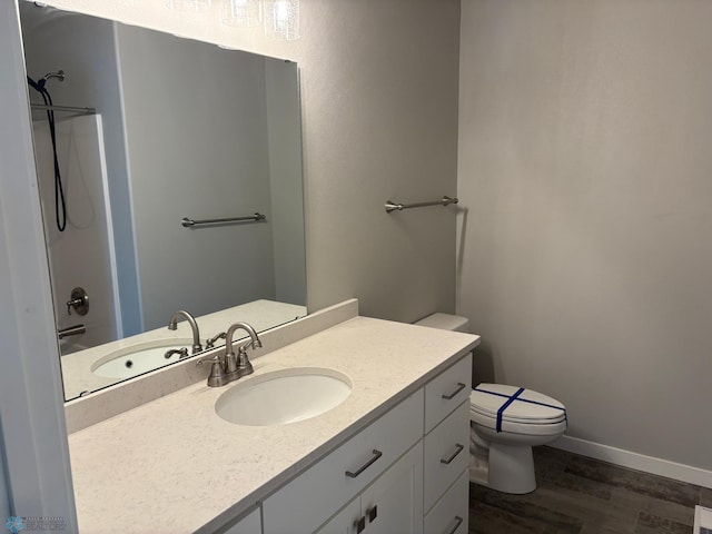 bathroom with vanity, wood-type flooring, a shower, and toilet