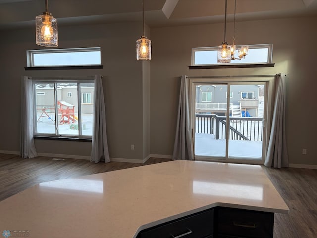 kitchen featuring dark hardwood / wood-style flooring, hanging light fixtures, and a notable chandelier