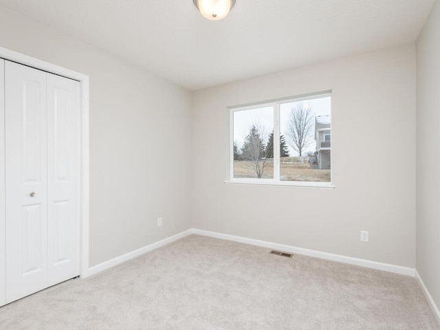 unfurnished bedroom featuring a closet and light carpet