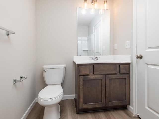 bathroom featuring wood-type flooring, vanity, and toilet