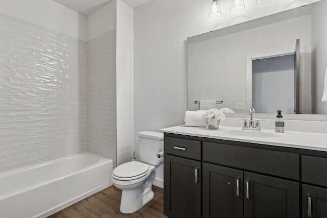 full bathroom featuring tiled shower / bath combo, wood-type flooring, vanity, and toilet