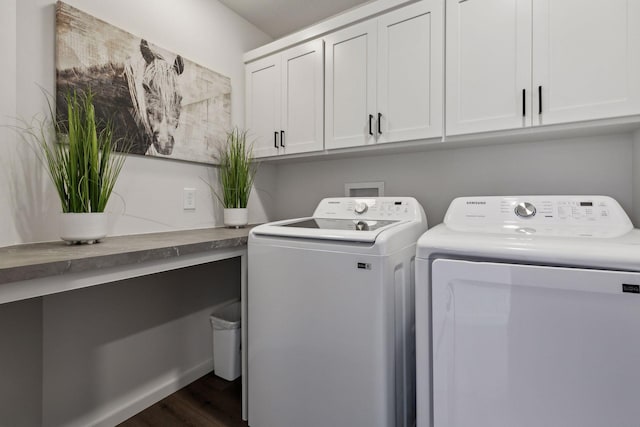 laundry room featuring cabinets, dark wood-type flooring, and washer and dryer