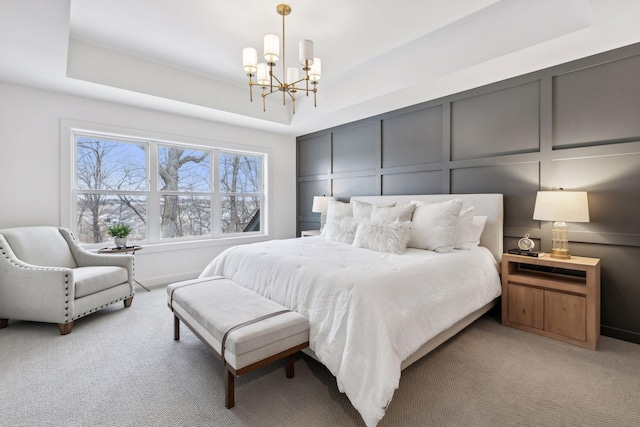 bedroom with an inviting chandelier, a tray ceiling, and light colored carpet