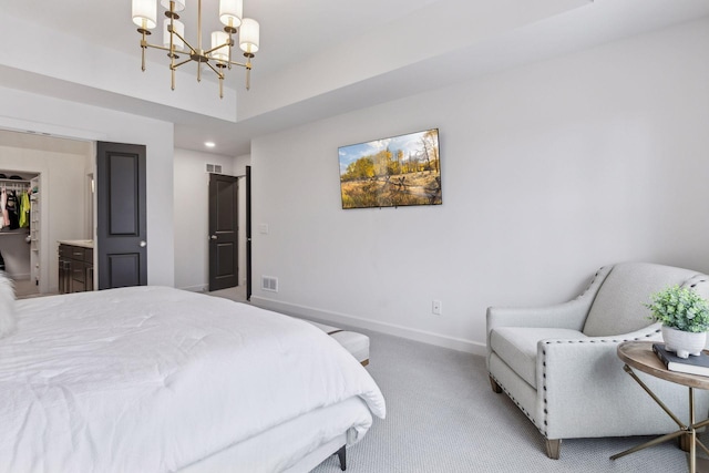 carpeted bedroom featuring a walk in closet and a chandelier