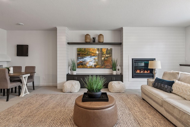 carpeted living room with a textured ceiling and a fireplace