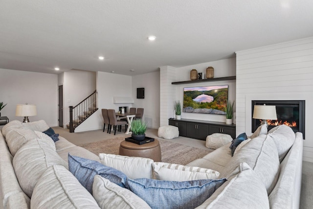 living room featuring a large fireplace and carpet