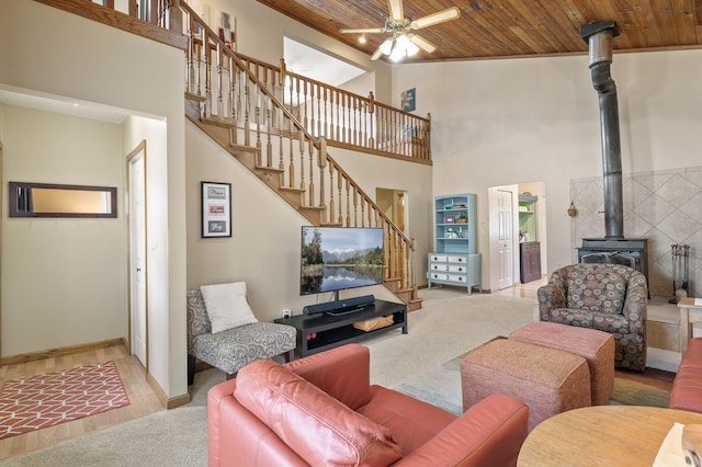 carpeted living room featuring stairs, high vaulted ceiling, wooden ceiling, and a wood stove