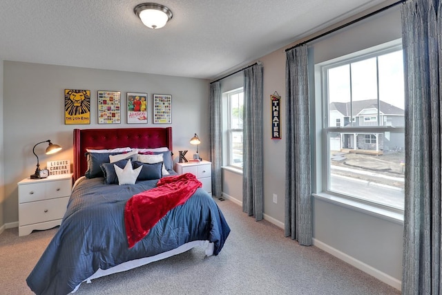 carpeted bedroom with a textured ceiling and baseboards