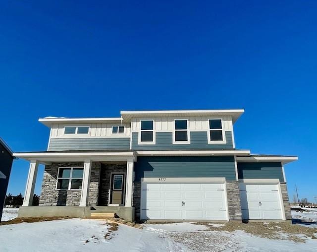 view of front of property featuring a garage, stone siding, a porch, and board and batten siding