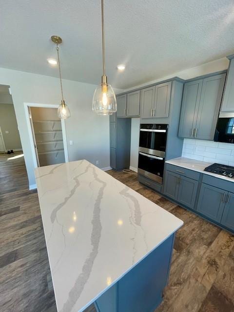 kitchen featuring black gas cooktop, double oven, dark wood-type flooring, and backsplash