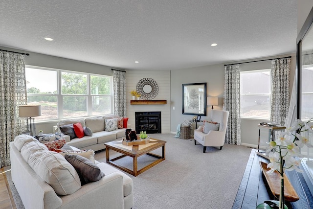 living room featuring a fireplace, carpet flooring, a textured ceiling, and recessed lighting