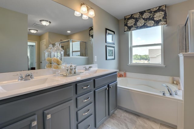 bathroom with double vanity, a garden tub, marble finish floor, a shower stall, and a sink