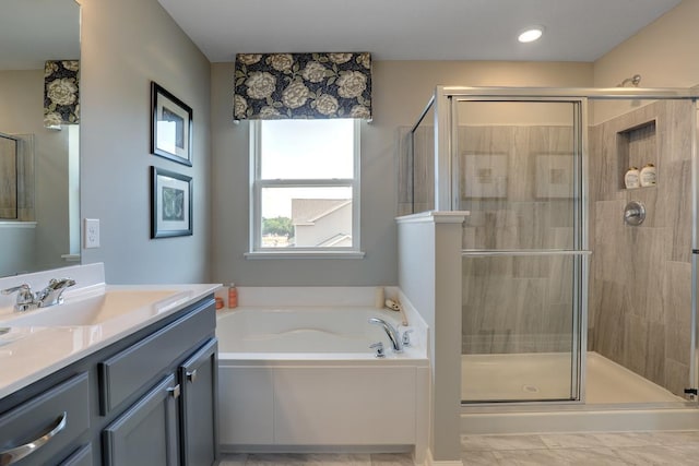 bathroom featuring a stall shower, a bath, and vanity