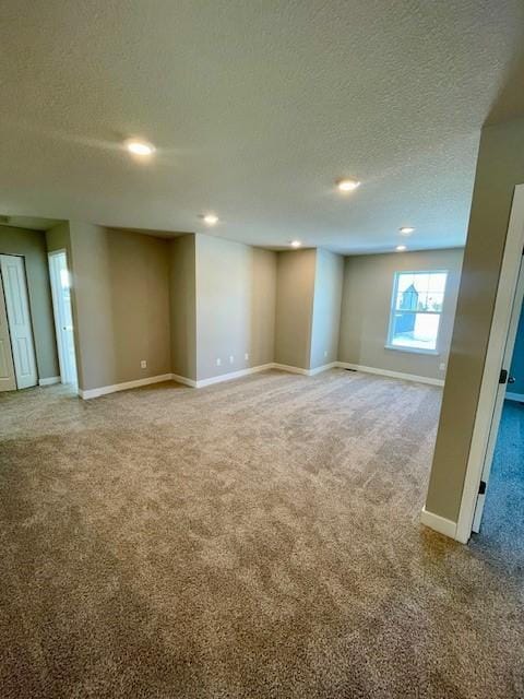 empty room with carpet floors and a textured ceiling