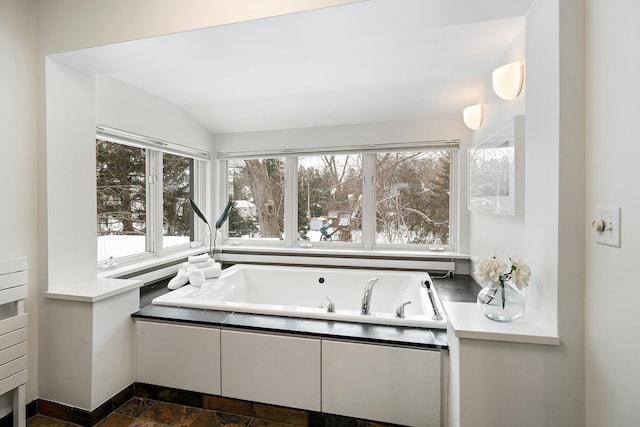 bathroom with a bathing tub and lofted ceiling