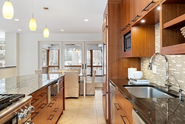 kitchen featuring sink, dark stone countertops, backsplash, hanging light fixtures, and french doors