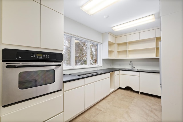 kitchen with white cabinets, sink, oven, and black electric cooktop