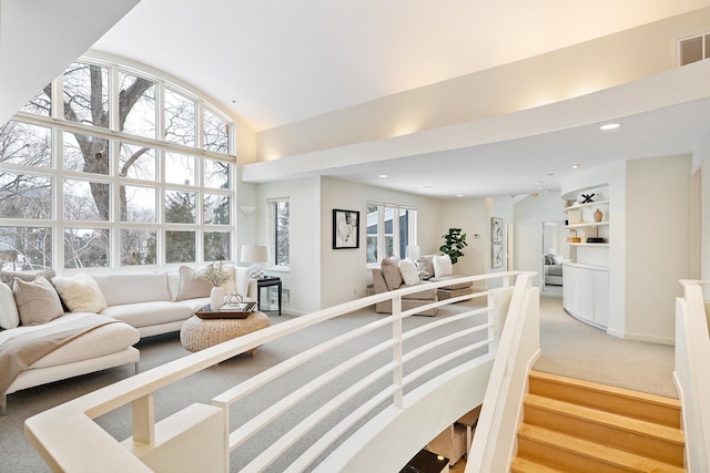 carpeted living room with high vaulted ceiling