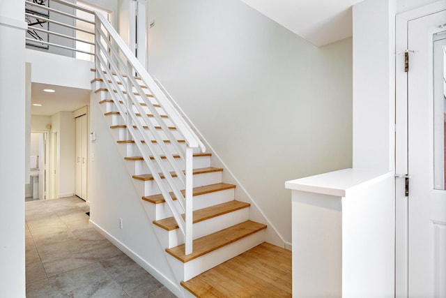 stairs with tile patterned flooring and a high ceiling