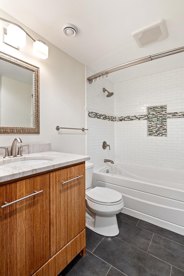 full bathroom with tiled shower / bath, vanity, toilet, and tile patterned flooring