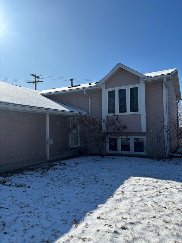 view of snow covered rear of property