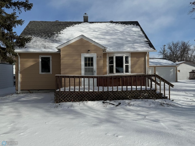 snow covered rear of property with a garage