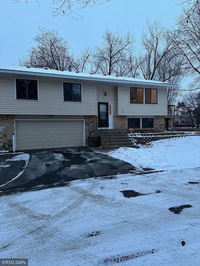 raised ranch with cooling unit and a garage