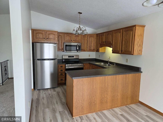 kitchen featuring lofted ceiling, sink, stainless steel appliances, a notable chandelier, and kitchen peninsula