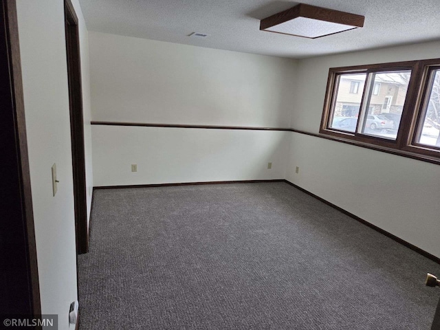 carpeted empty room with a textured ceiling