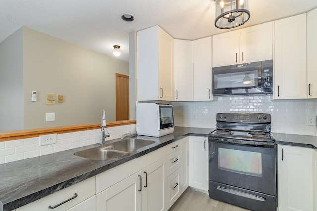 kitchen with sink, light hardwood / wood-style flooring, white cabinetry, black appliances, and decorative backsplash