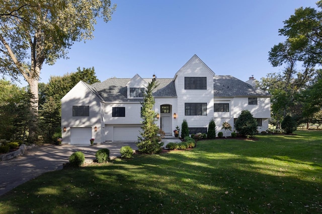 view of front of home with a garage and a front lawn