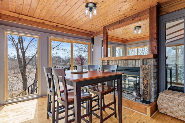 dining area with a multi sided fireplace, a healthy amount of sunlight, and hardwood / wood-style flooring