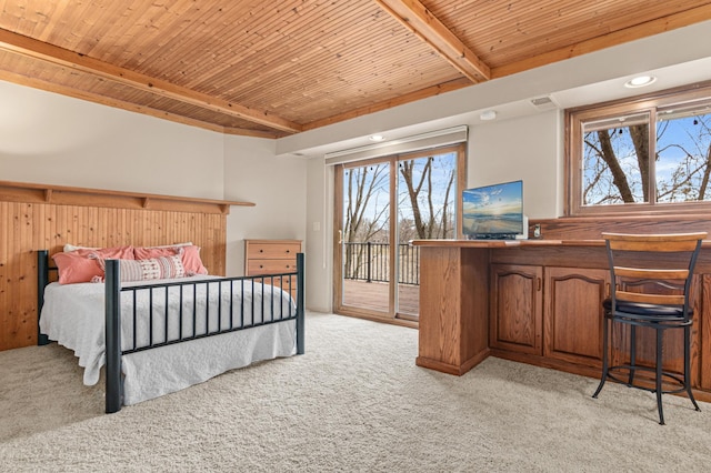 bedroom featuring multiple windows, light carpet, beam ceiling, and access to exterior