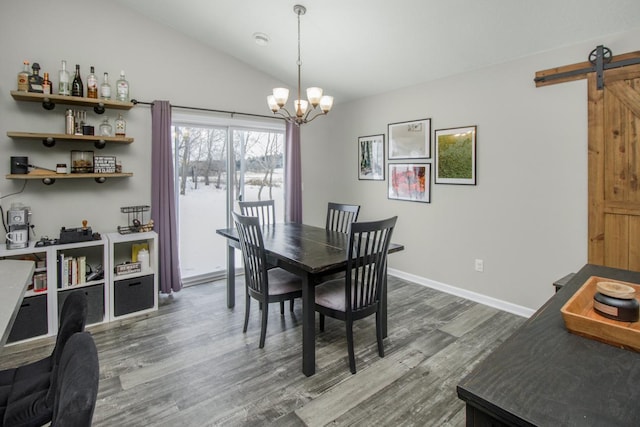 dining space with a barn door, an inviting chandelier, lofted ceiling, and dark hardwood / wood-style flooring