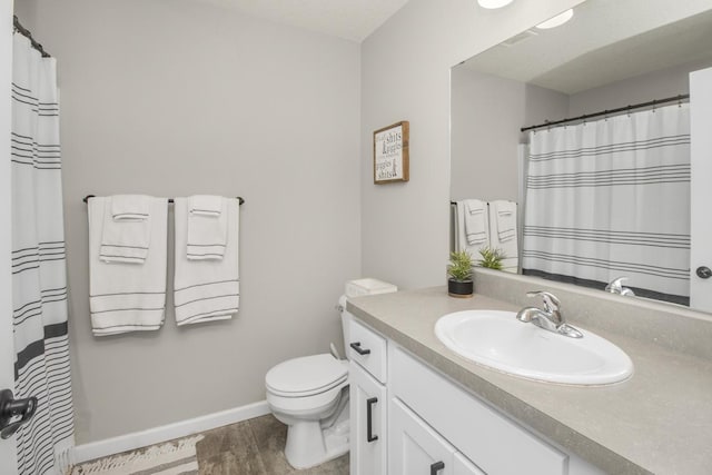 bathroom with vanity, wood-type flooring, and toilet