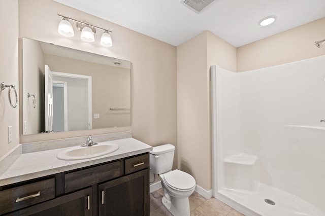 bathroom featuring vanity, tile patterned floors, toilet, and a shower