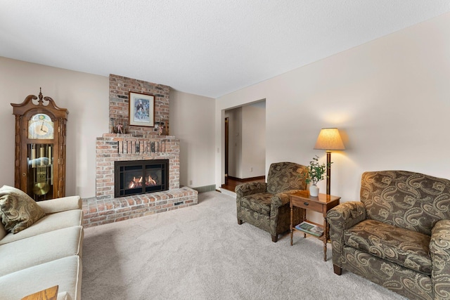 carpeted living room featuring a brick fireplace and a textured ceiling