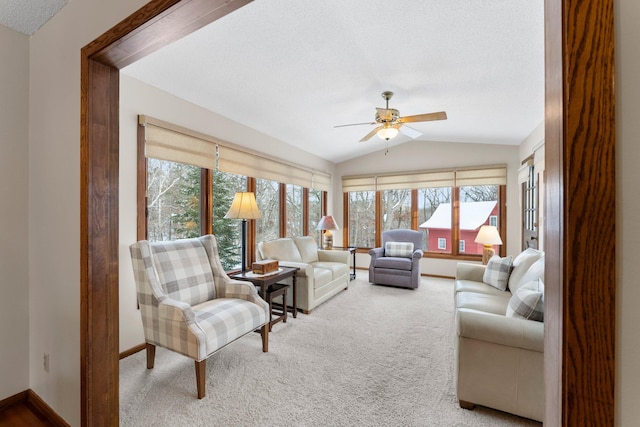 living room featuring vaulted ceiling, carpet, a textured ceiling, and ceiling fan