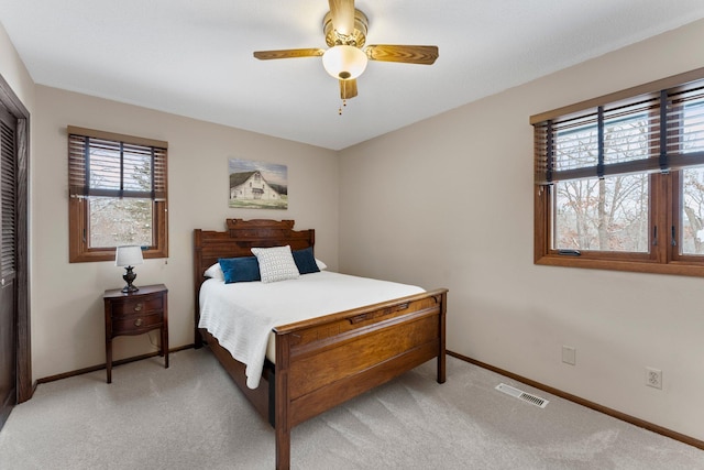 carpeted bedroom with ceiling fan and a closet