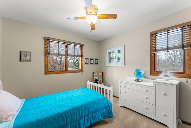 bedroom featuring multiple windows, light carpet, and ceiling fan