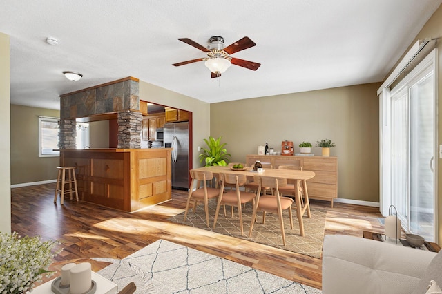 dining room with light wood-style flooring, baseboards, and ceiling fan